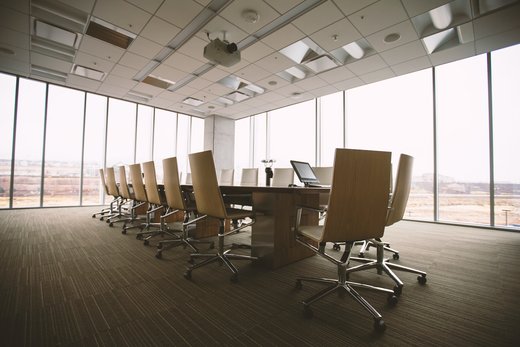 a spacious conference room featuring expansive glass windows that welcome abundant natural light on a sunny day