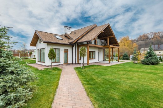 a cozy small house with a vast green front yard, basking in the warmth of a sunny day. 