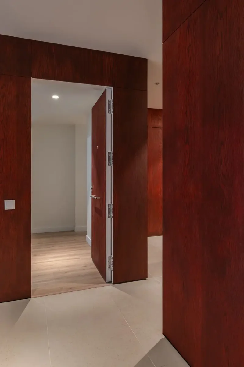 Entrada con puerta de madera y revestimiento elegante