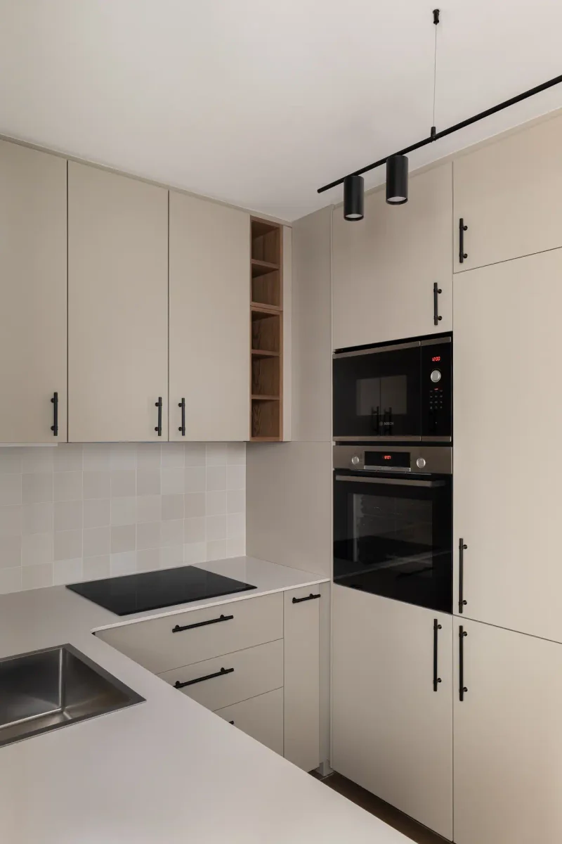 Cocina moderna blanca con electrodomésticos negros