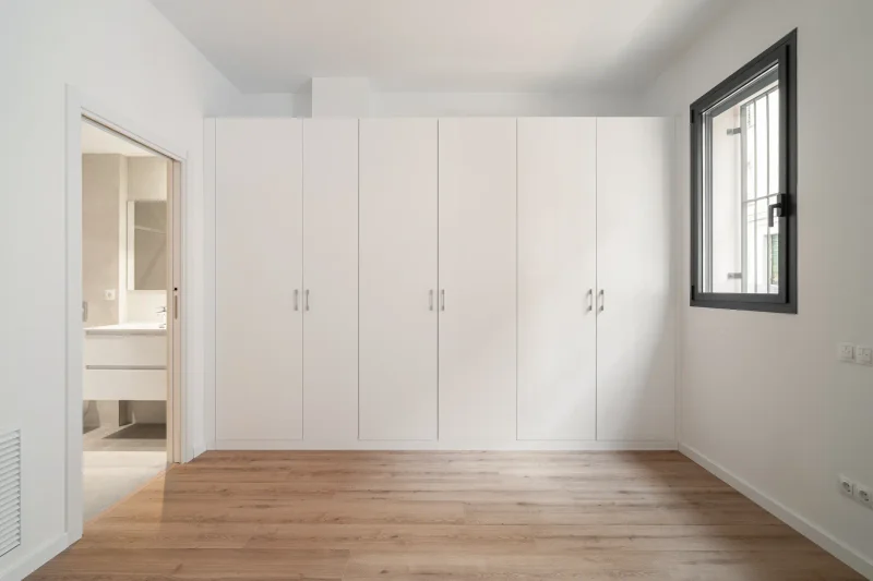 Dormitorio luminoso con armario blanco y suelo de madera