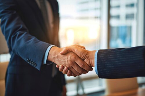 Two people shaking hands in business attire.