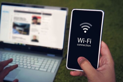 A person holding their phone, connecting to Wi-Fi