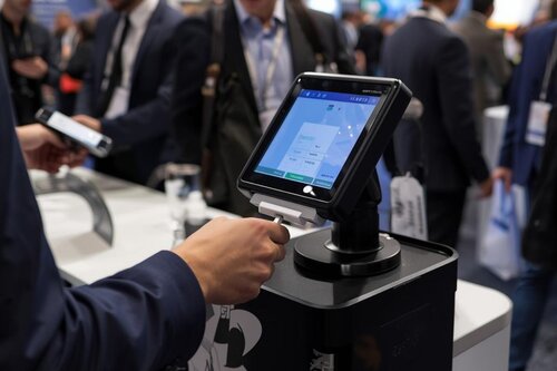A badge scanner operating at a trade show with someone scanning their badge.