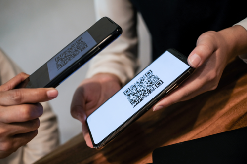 Photo of someone scanning a QR code at a trade show on their phone.