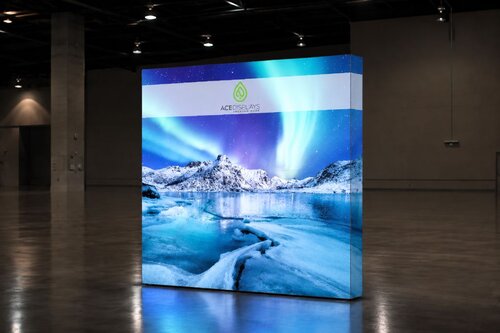 Lumos 8ft x 8ft flat backlit display with northern lights design and Ace Displays logo in dark empty warehouse, reflecting on ground 