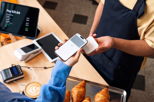 Two people exchanging contact details via smartphone.