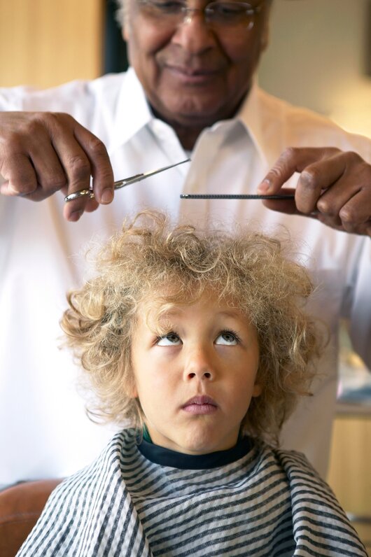 Barber at work — cutting a child's hair.