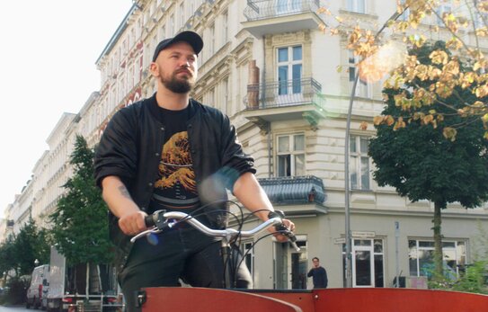 Marian riding his bike through an urban backdrop