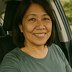 Lynn from Boise sits in the driver's seat of a car and smiles at the camera in a close-up selfie.