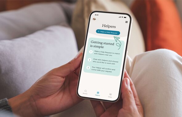 A person holds a smartphone displaying a step-by-step guide on how to request and book a Helper through an app.