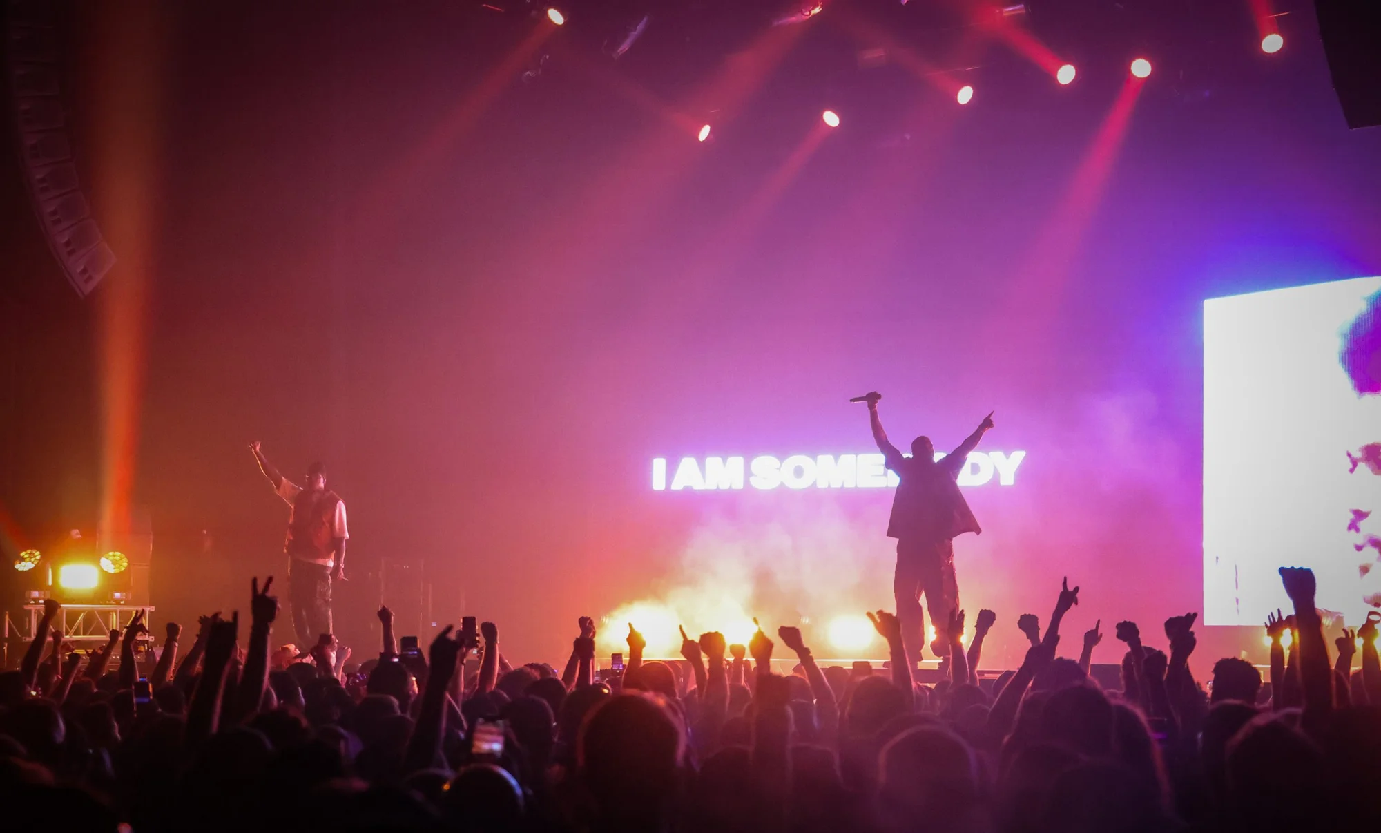 Clipse commanding the crowd on stage, with “I AM SOMEBODY” 