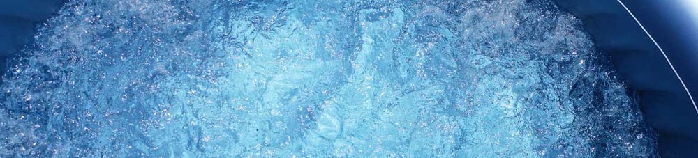 Sprudelndes Wasser in einem aufblasbaren Whirlpool aus der Vogelperspektive.