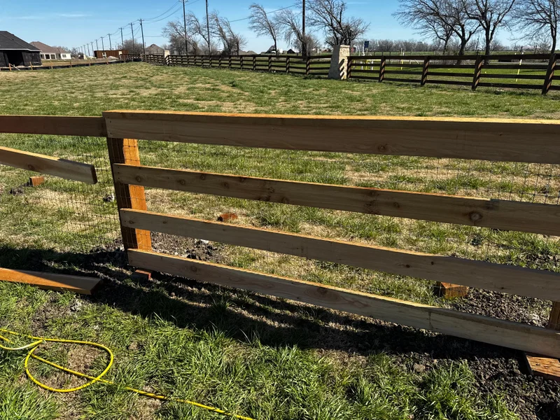 Three-rail wood fence with welded wire backing