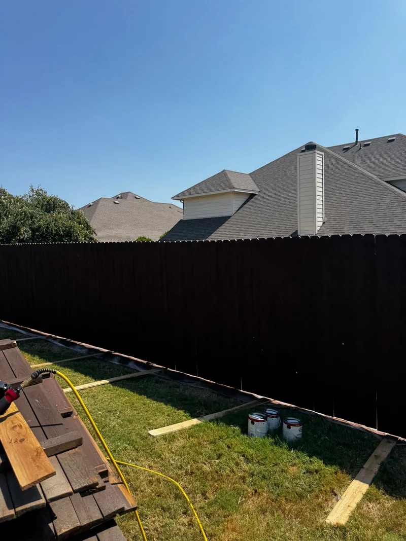 Freshly stained dark wood privacy fence