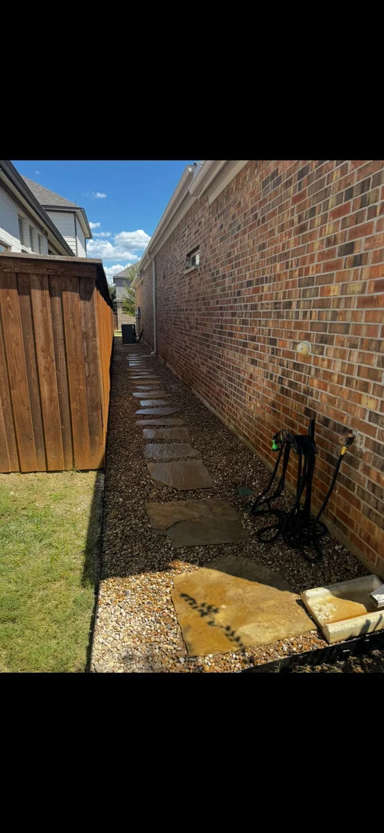 Completed landscape project with new stone walkway and gravel path