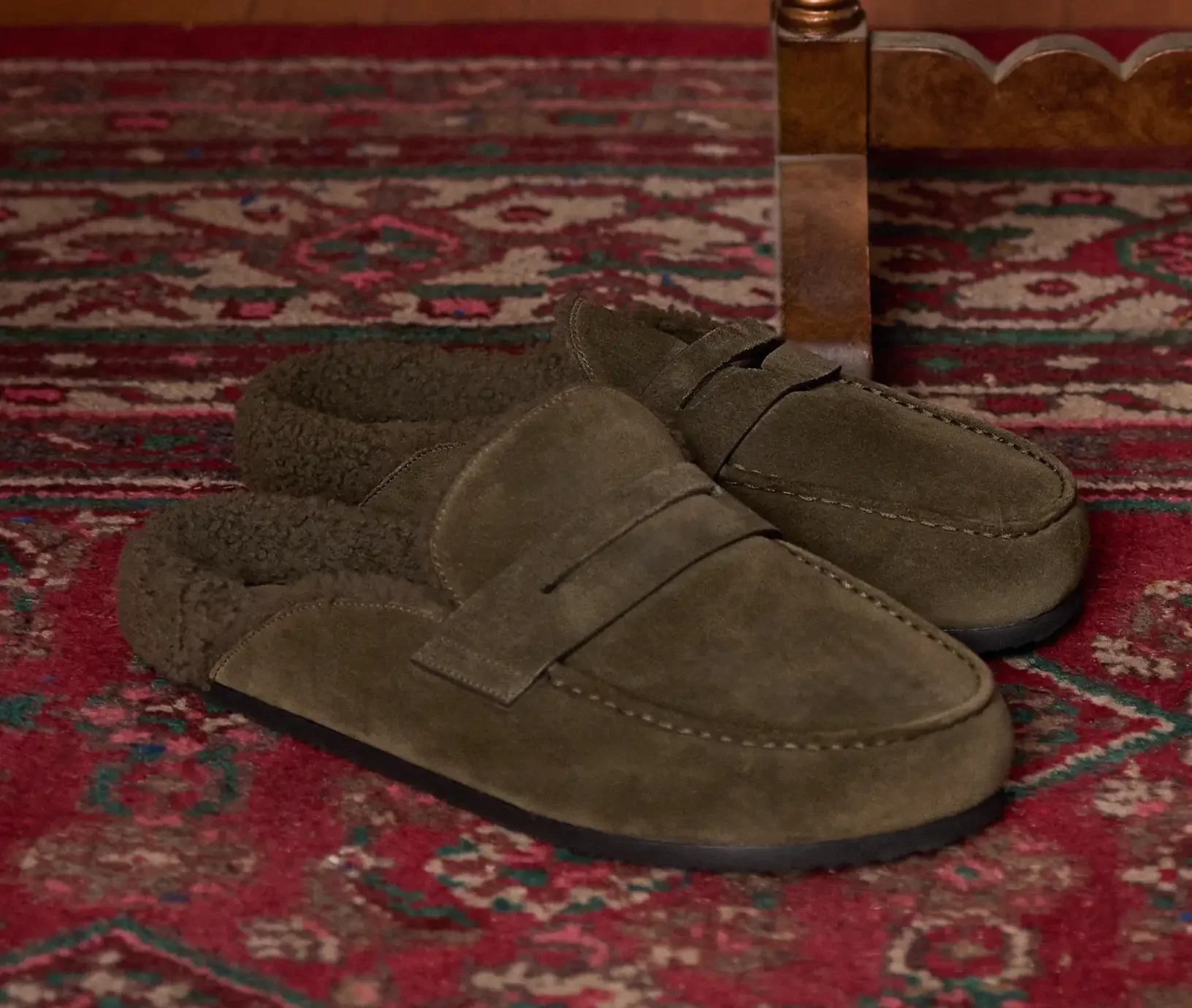 A pair of army green suede loafer slide shoes