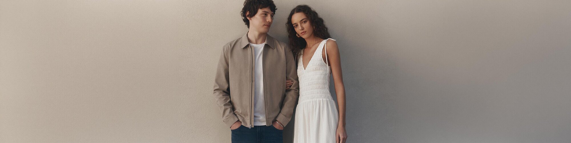 Woman wearing a blue blouse with light wash jeans and a brown belt. Man wearing a dark wash denim shirt.