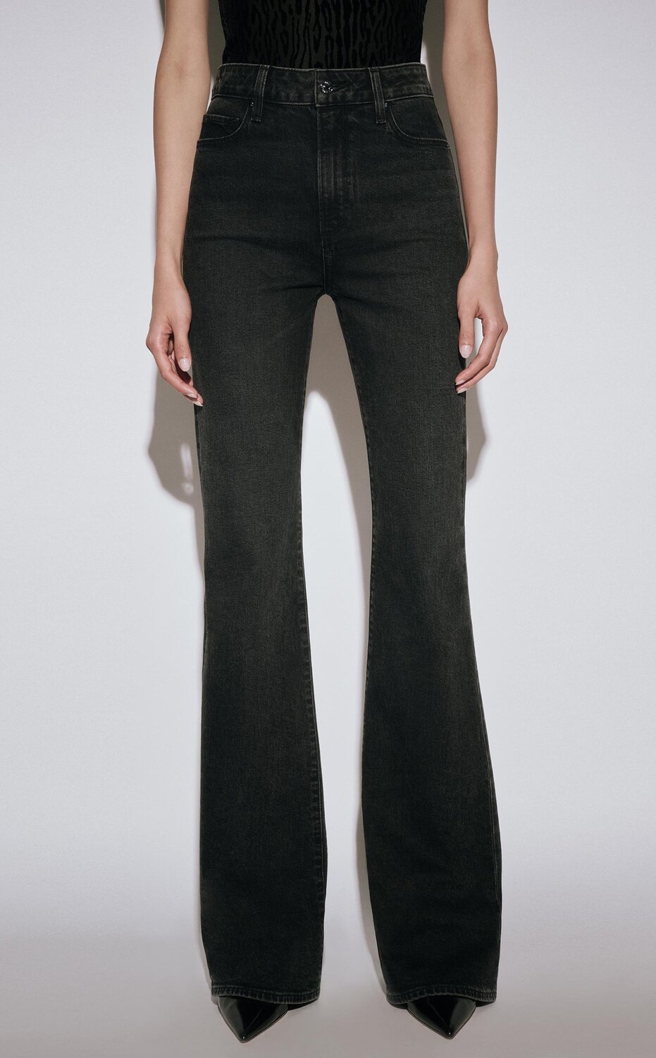 Woman wearing a black velvet leopard printed tee with black flare jeans and black pumps