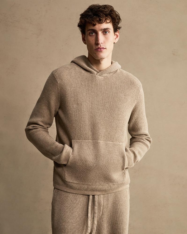 Man wearing a dark brown knit sweater and sweatpants