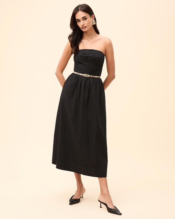 Woman wearing a black strapless A-line dress, snake-printed belt, and black pointed toe heels