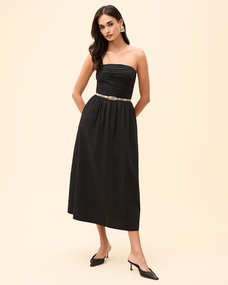 Woman wearing a black strapless A-line dress, snake-printed belt, and black pointed toe heels