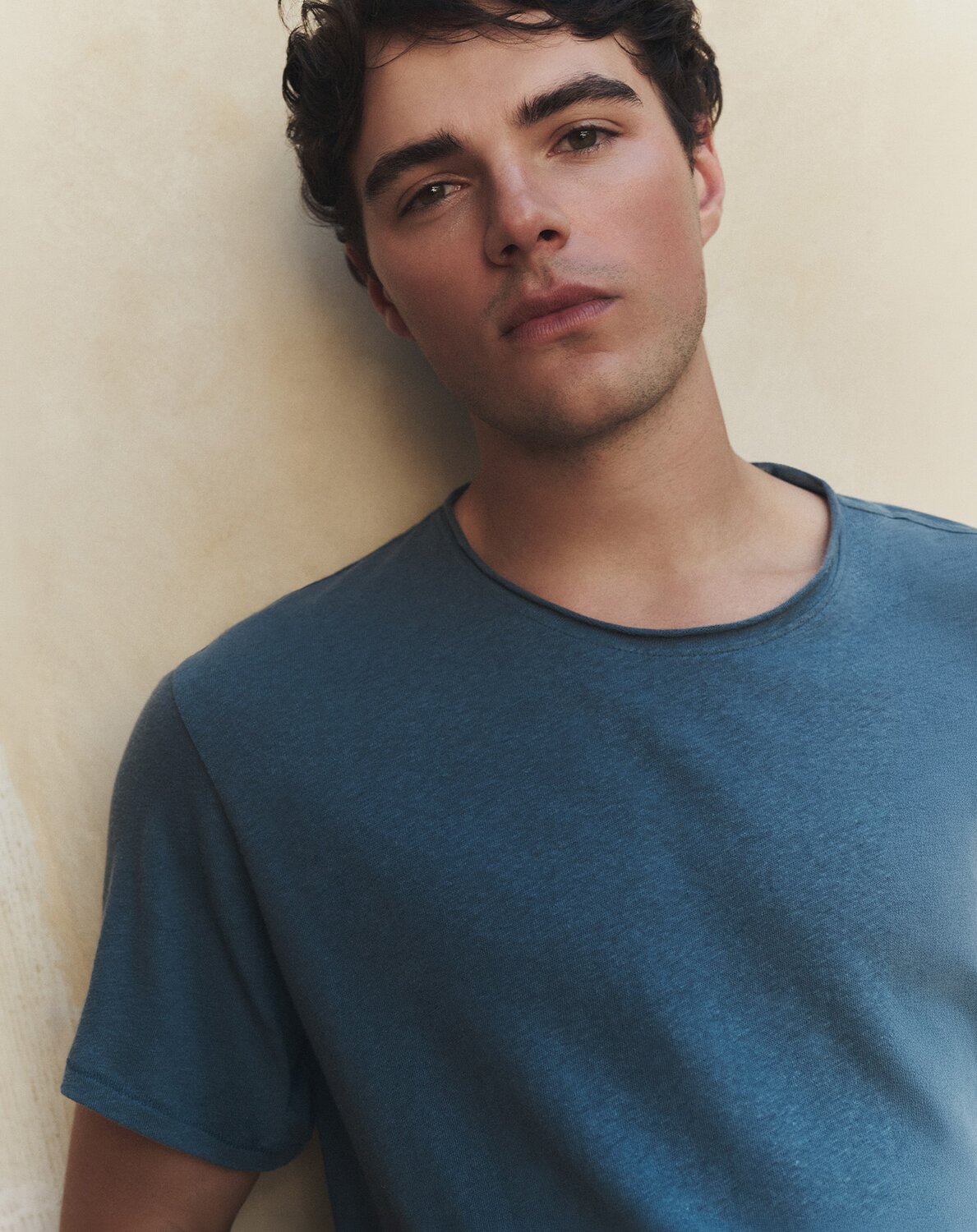 Close-up shot of a man wearing a blue tee.