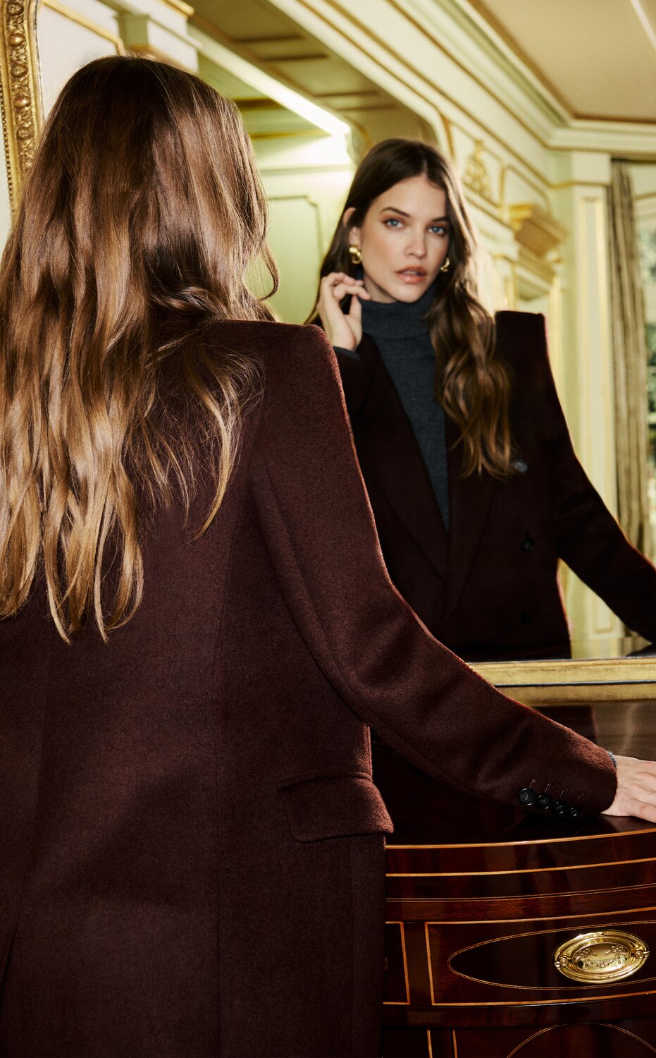 Model wearing a tailored brown blazer, charcoal turtleneck, and black pants from the PAIGE women's new arrivals collection.