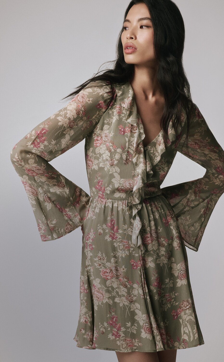Woman wearing a green long sleeve floral mini dress with tall auburn boots