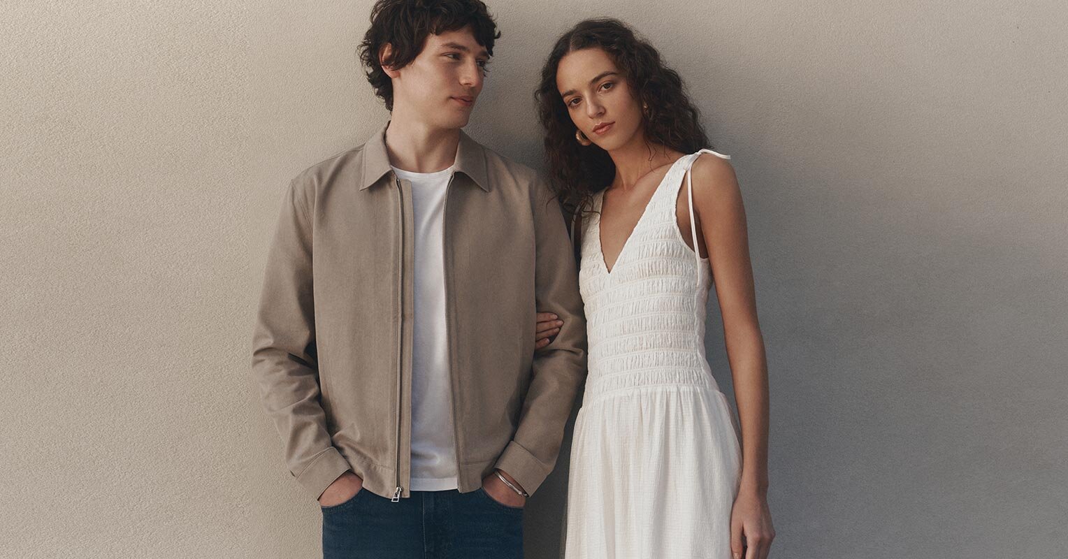 Woman wearing a blue blouse with light wash jeans and a brown belt. Man wearing a dark wash denim shirt.