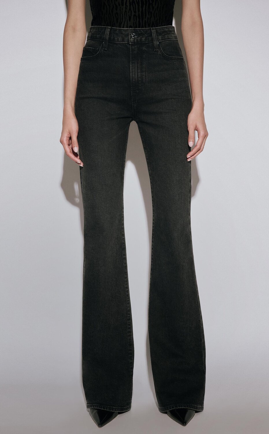 Woman wearing a black velvet leopard printed tee with black flare jeans and black pumps