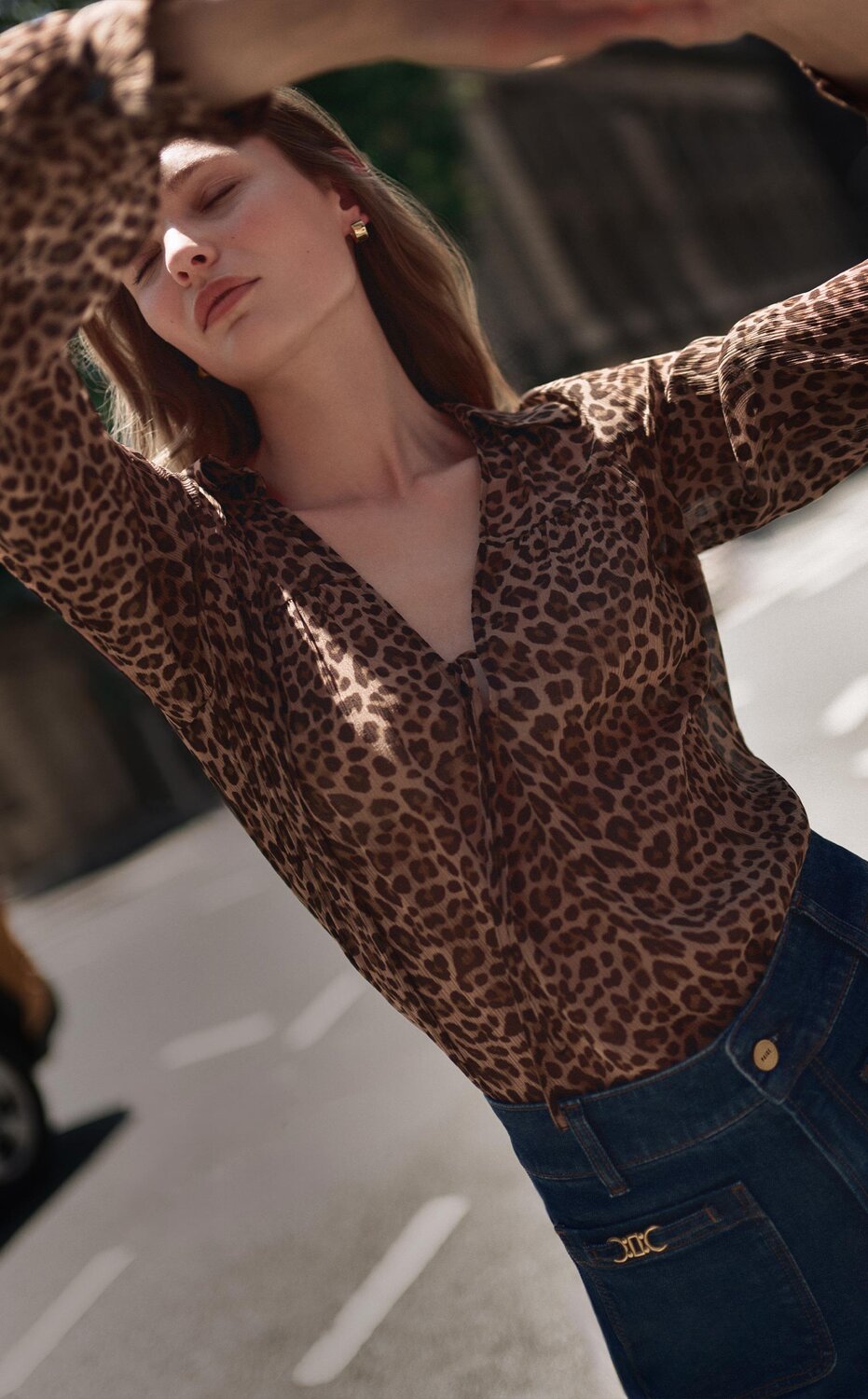 Woman wearing a long sleeve leopard print blouse with dark wash jeans; woman wearing a leopard printed midi skirt with a black cardigan