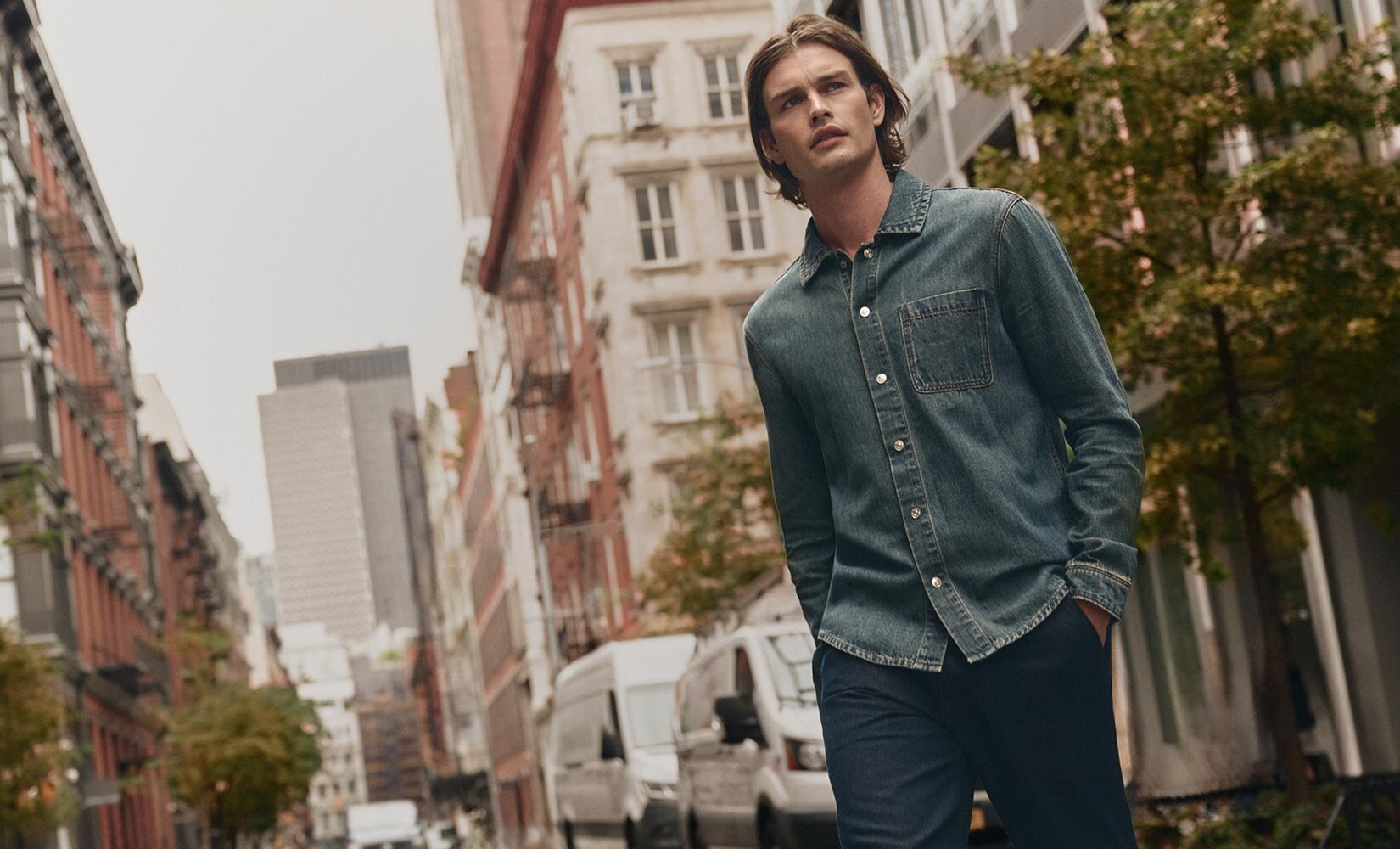 Man wearing a medium wash denim shirt and dark wash denim trousers