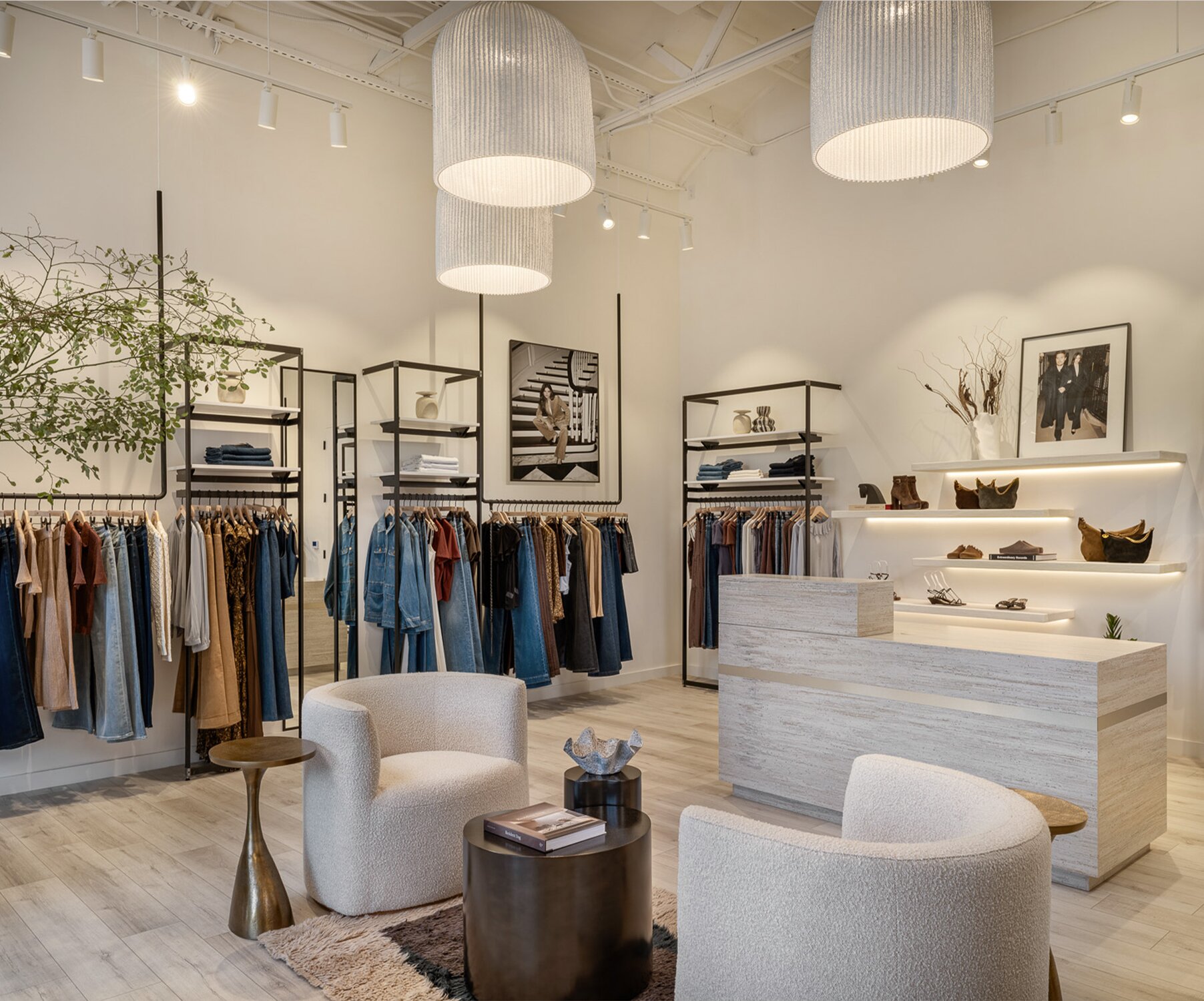 Interior of the PAIGE Palisades Village retail store featuring clothing racks, modern furnishings, and curated displays of denim and apparel.