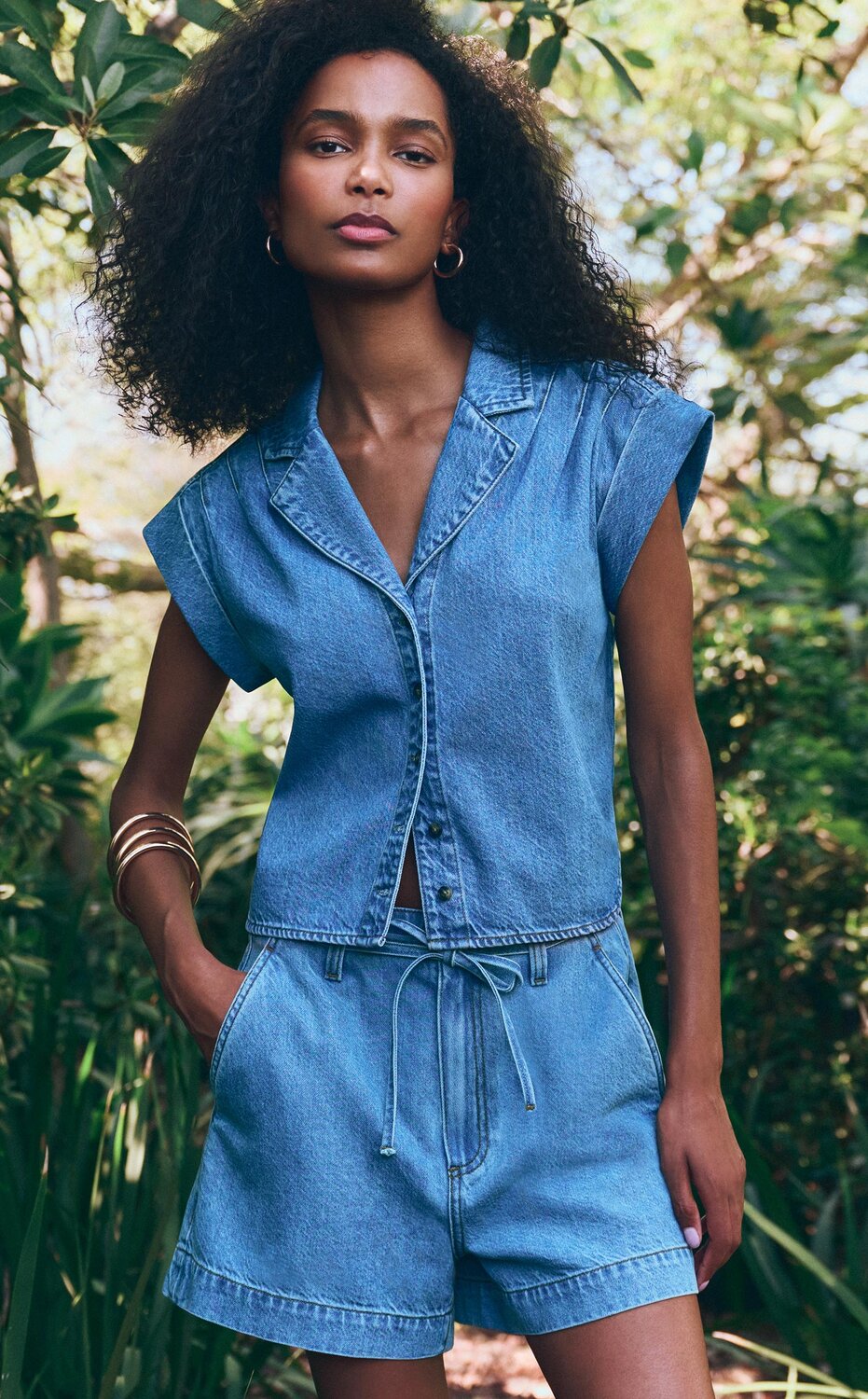 Woman wearing a matching denim short sleeve top and shorts set