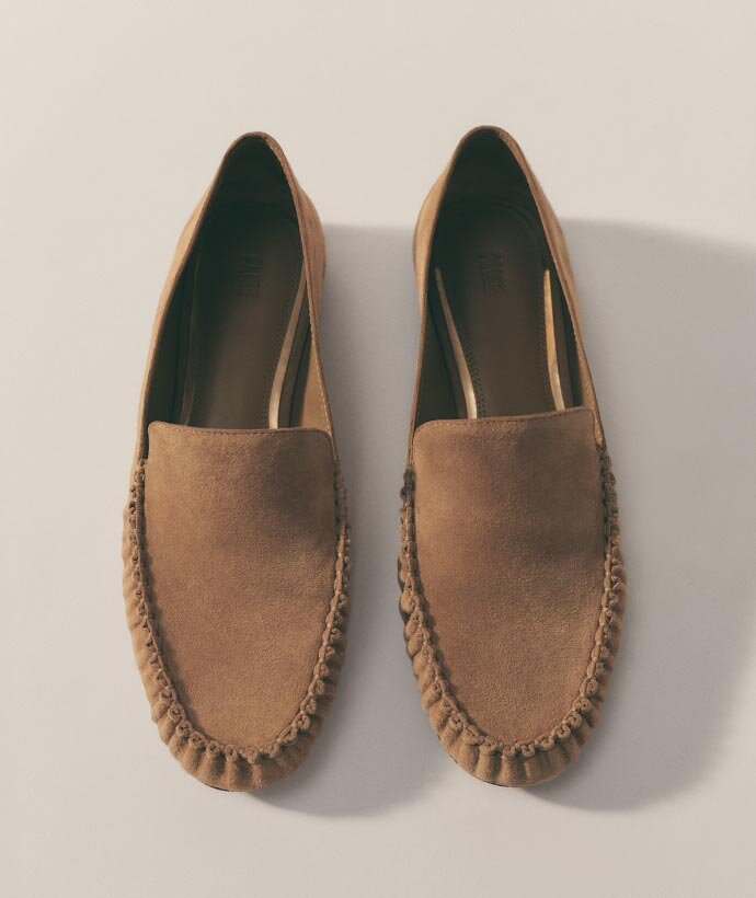 A pair of tan suede slip on loafers with ruched detail by PAIGE.