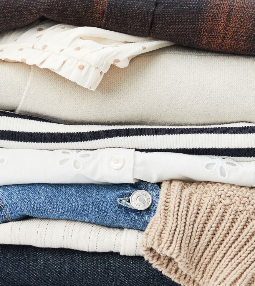 Stack of men's and women's folded clothing