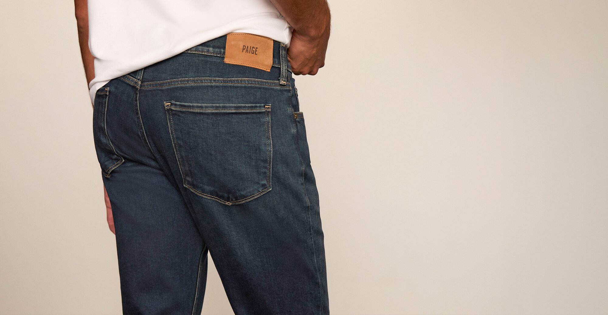 Man wearing a pair of dark wash jeans and a white t-shirt