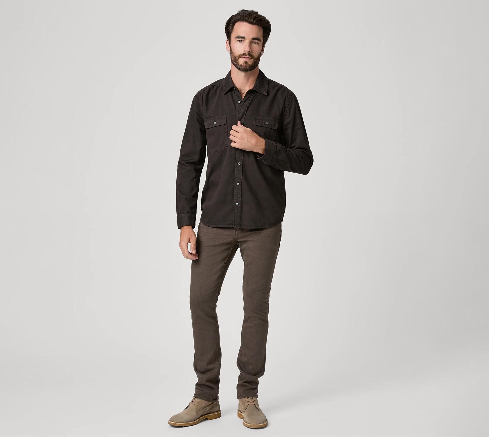Man wearing a dark brown button up shirt with brown jeans and taupe boots