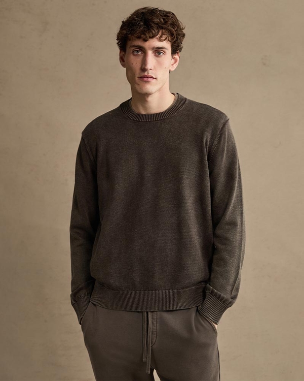 Man wearing a dark brown knit sweater and sweatpants