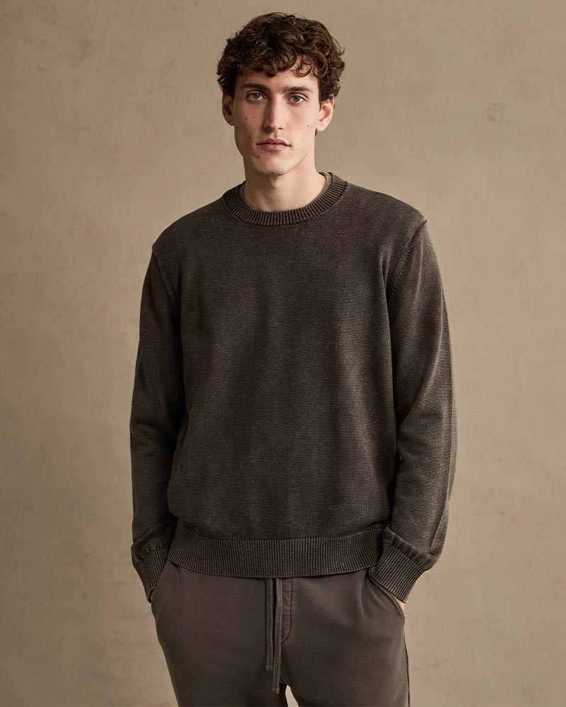 Man wearing a dark brown knit sweater and sweatpants