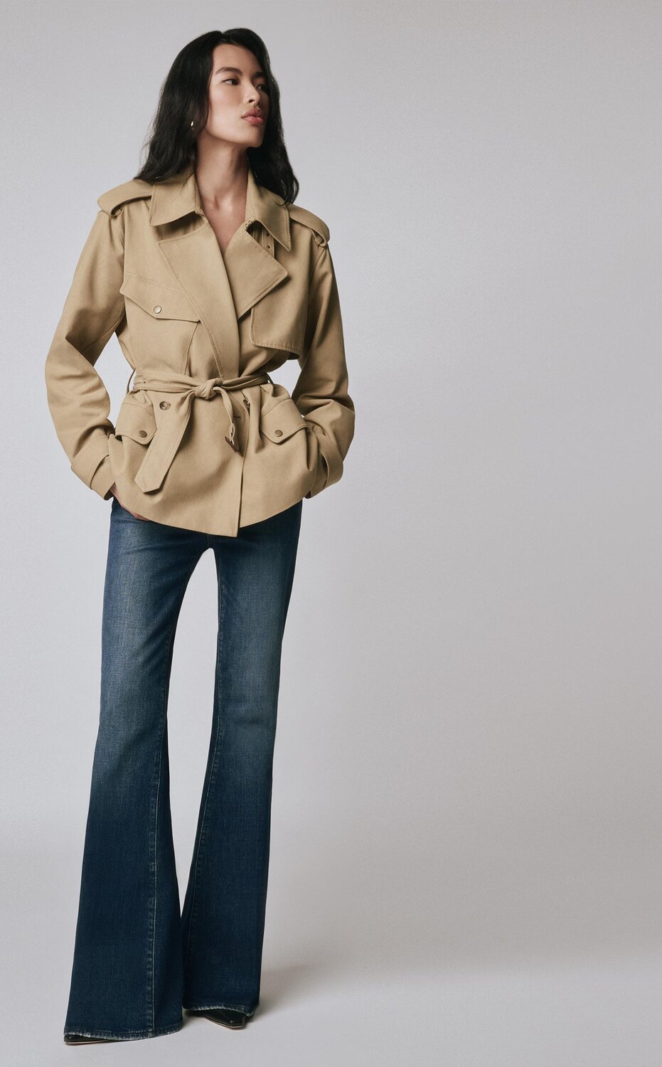 Woman wearing a khaki jacket with dark wash flare jeans and black boots