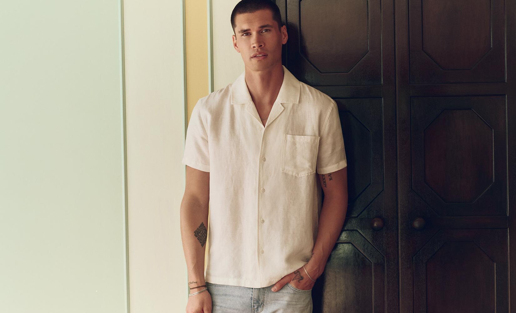 Man wearing a white short sleeve button down shirt and light wash jeans
