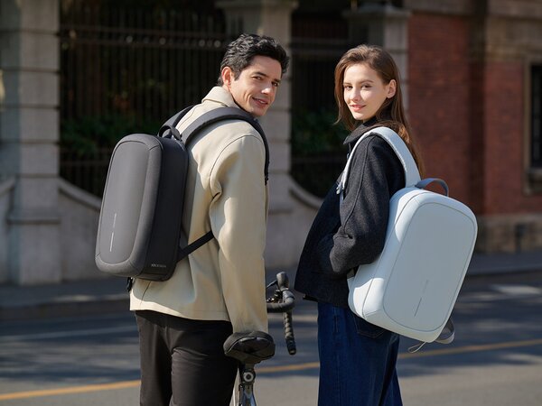 En mann og en kvinne iført XD Design-ryggsekker, står i en bygate og ser tilbake mot kamera.