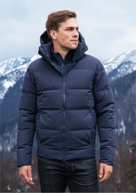 Mann iført Tracker dunjakke i fjellandskap