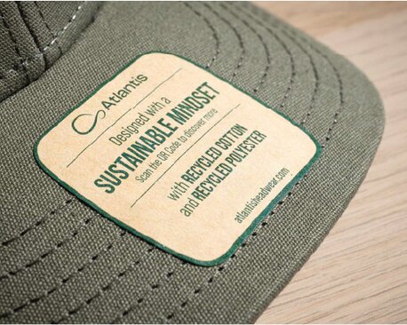 Nærbilde av en grønn caps med bærekraftig merkelapp fra Atlantis.
