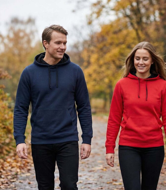 To personer iført Clique Classic Hettegenser i høstfarger – allsidig og komfortabel hettegenser til hverdag og fritid. 