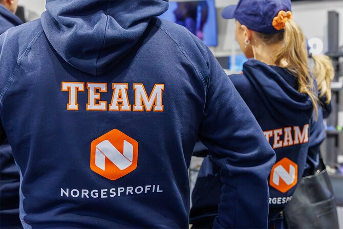 Marineblå hettegenser med brodert og trykket firmalogo og teksten "TEAM". Perfekt for ansatte, eventer og teamwear for økt profilering og profesjonelt utseende