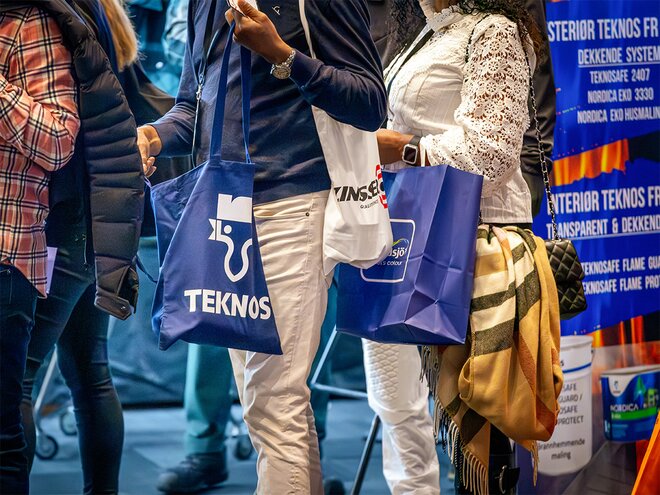 Messebesøkere med profilerte handlenett i blått og hvitt – praktiske og synlige profilartikler for bedrifter og arrangementer.