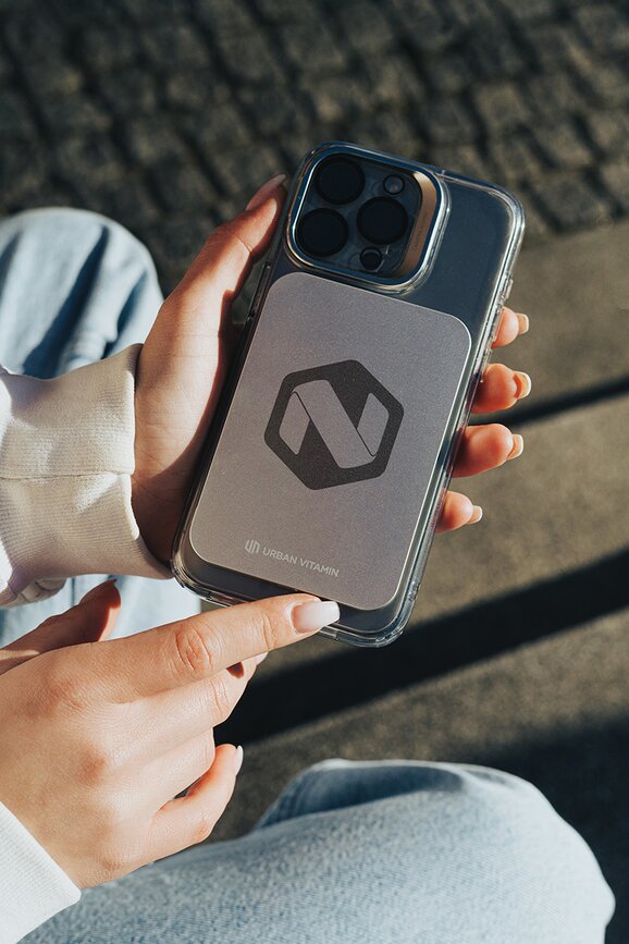 Magnetisk powerbank med firmalogo, plassert under en mobiltelefon. Perfekt profileringsprodukt og firmagave for bedrifter som ønsker økt synlighet og nytteverdi.